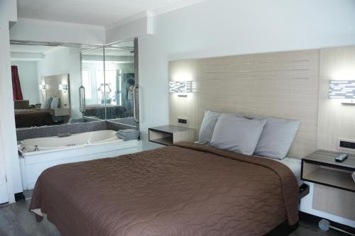 a hotel room with a bed and a bath tub at Relax Inn in Webster