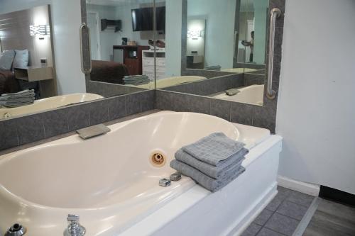a bathroom with a bath tub with a towel at Relax Inn in Webster