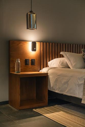 a bedroom with a bed with a wooden head board at Hotel Agua de Plata in San Luis Potosí