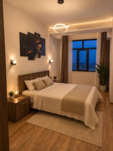 a bedroom with a large bed and a large window at Panorama in Sumqayıt