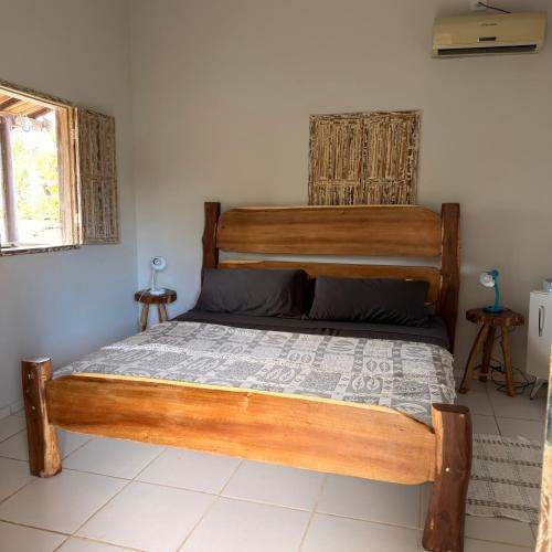 a bedroom with a wooden bed in a room at Kcasa13 in Corumbau