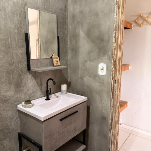 a bathroom with a sink and a mirror at Kcasa13 in Corumbau