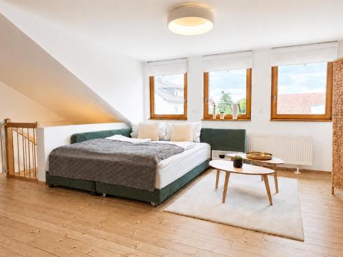 a bedroom with a bed and a table and windows at Modernes Ferienhaus mit großer Küche, Terrasse & Garten in Bad Camberg