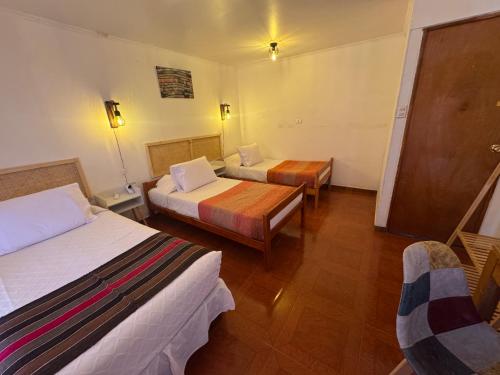 a hotel room with two beds and a table at Hotel Turi Atacama in San Pedro de Atacama