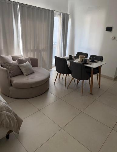 a living room with a couch and a table and chairs at Aura Residence in Comodoro Rivadavia