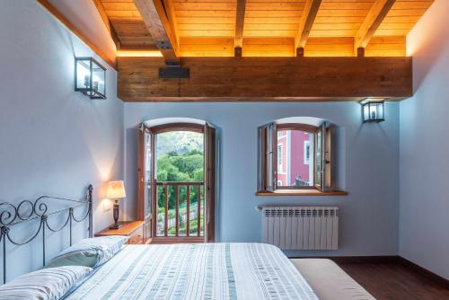 a bedroom with a bed and a window at Casa Llanes con Jardín, Vistas y Barbacoa – Maruja in La Pereda de Llanes
