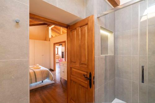 a bathroom with a shower and a wooden door at Casa Llanes con Jardín, Vistas y Barbacoa – Maruja in La Pereda de Llanes