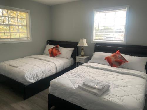 two beds in a room with two windows at Private guest rooms & baths in Atlanta