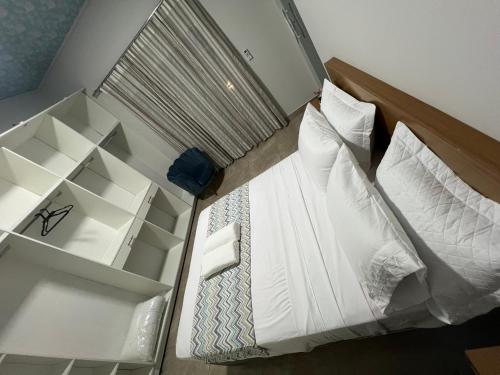 a bedroom with a bed with white sheets and pillows at Casa Quinta Locha in Ciudad del Este