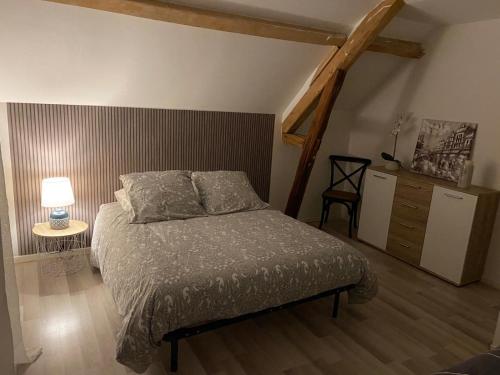 a bedroom with a bed and a table with a lamp at Villa des marots in Troyes