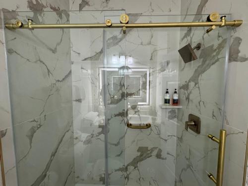 a bathroom with a shower with a glass door at Athens Hotel & Suites in Houston