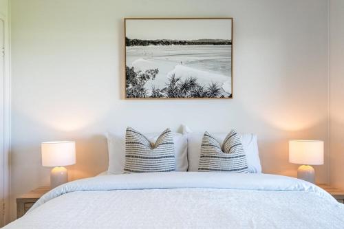 a bedroom with a white bed with two lamps at Absolute Beachfront Apartment 3B in Lennox Head