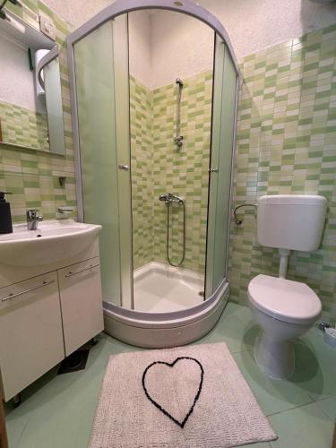 a bathroom with a shower with a heart drawn on the floor at Apartmani Znaor in Baška Voda