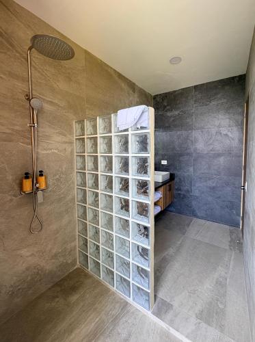 a shower with a glass block wall in a bathroom at Casa de Mar Hotel And Villas in La Libertad