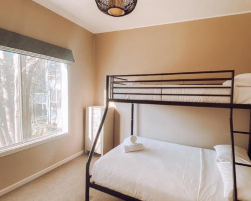 a bedroom with a bunk bed and a window at Snow Gum Apartment 1 in Baw Baw Village