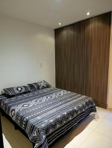 a bedroom with a large bed with a wooden door at Complejo Carrodilla4 in Ciudad Lujan de Cuyo