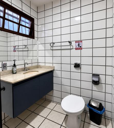 a bathroom with a toilet and a sink at Sossai Hostel in Vitória