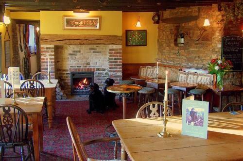 a dog sitting in front of a fireplace in a restaurant at The Hunters Rest Inn in Clutton