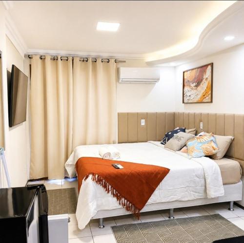 a bedroom with a large bed and a television at Quarto triplo em Petrópolis in Natal