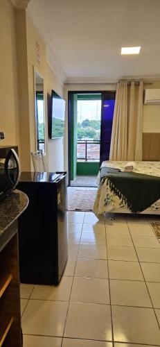 a hotel room with a bed and a balcony at Quarto triplo em Petrópolis in Natal