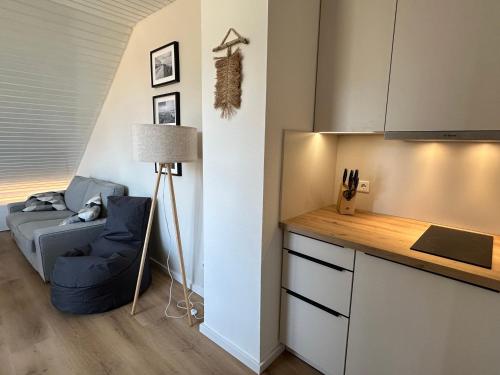 a living room with a blue chair and a couch at Strandloft Pippa in Borkum