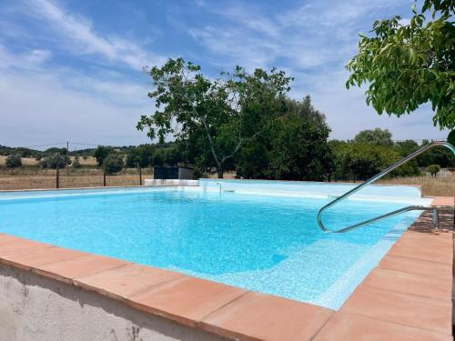 a large blue swimming pool with a metal hose at Quinta do Céu Tranquilidade e Piscina no Alentejo in Alvito