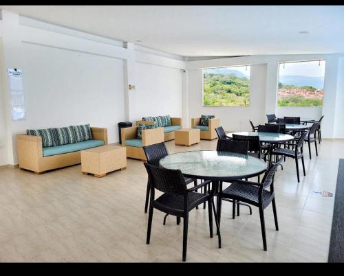 a room with tables and chairs and a couch at Apartamento san gil plaza in San Gil