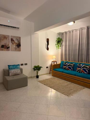 a living room with a blue couch and a chair at Isla de margarita in Pampatar