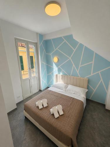 a bedroom with a bed with two towels on it at Alassio Attico con Terrazza AC WIFI in Alassio