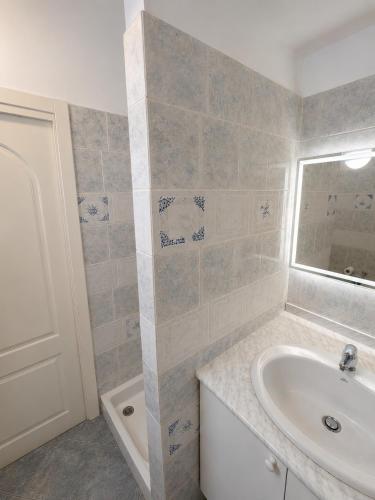a bathroom with a sink and a tub at Alassio Attico con Terrazza AC WIFI in Alassio