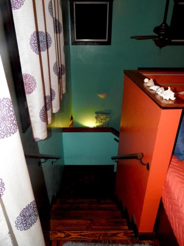 a room with a bed and a dresser and a staircase at Kalani Hawaii Private Lodging in Pupukea
