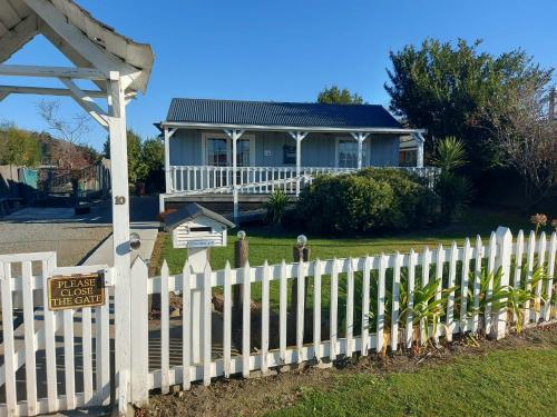 a white picket fence in front of a house at The Cosy Nook in Waimate