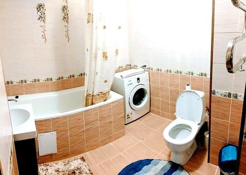 ein Badezimmer mit einem WC und einer Waschmaschine in der Unterkunft Apartment on Sauran Str Center in Astana
