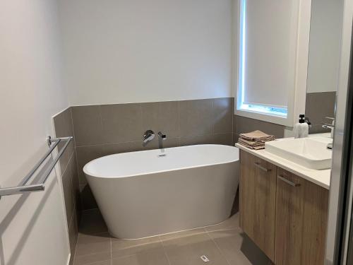 a white bath tub in a bathroom with a sink at PONZ Lake Retreat - Nagambie in Nagambie