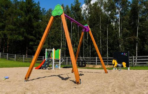 a playground with two swings in a park at Camping Szelągówka in Sorkwity