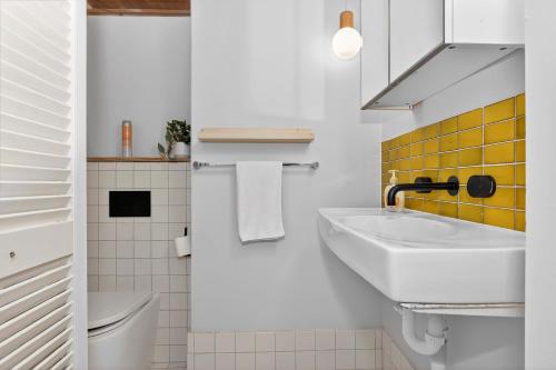 a white bathroom with a sink and a toilet at Ada Art Deco by Host Solutions Hutt St, Heritage in Adelaide