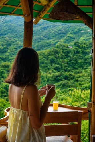 Eine Frau in einem weißen Kleid, die ein Glas Orangensaft hält in der Unterkunft Sol de Minca Eco Lodge in Minca