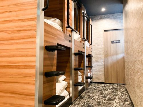 a walk in pantry with wooden walls and shelves at Hotel LiVEMAX Tendo in Tendo