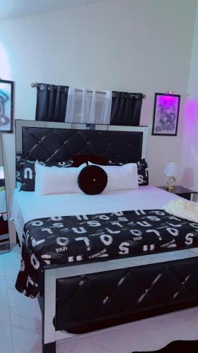 a bedroom with a bed with a black and white bedspread at Escape casa Ja in Portmore