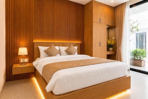 a bedroom with a large bed with wooden walls at Hotel K Seminyak in Badung