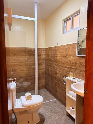 a bathroom with a toilet and a sink at Rufana Suites in Moalboal