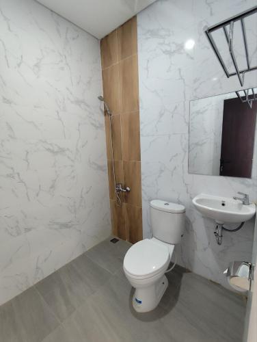 a bathroom with a toilet and a sink at Aisyi Tower Klaten in Klaten