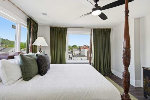 a bedroom with a large bed with a ceiling fan at The Bavarian Inn 6 Chic 1 BDR in Covington
