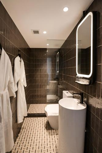 a bathroom with a sink and a toilet and a mirror at Link Hotel Singapore in Singapore