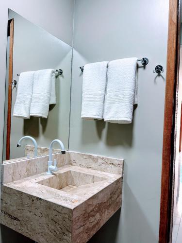 a bathroom with a marble sink and a mirror at Recanto Sole Luz in Piranhas