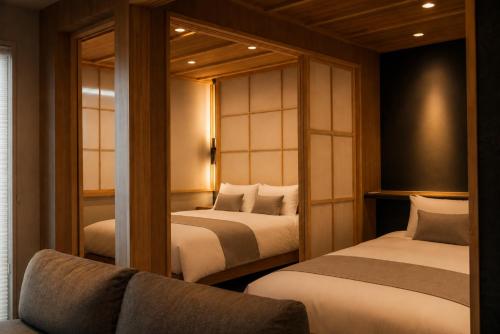 a room with two beds and a couch in it at Sugamo Winco Residence 新宿まで電車14分 巣鴨駅徒歩3分 光wifi エレベーター 商店街徒歩4分 in Tokyo