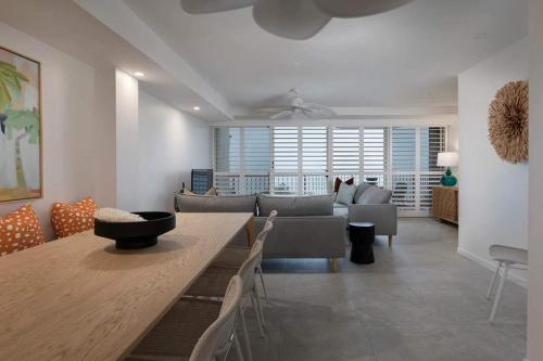 a living room with a couch and a table and chairs at Beachfront Villa in Coolum Beach