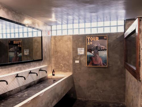 a bathroom with two sinks and a mirror at Outpost Beach Hostel in El Nido