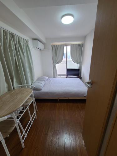 a small room with a bed and a table at Namba Ebisu Tower701 in Osaka