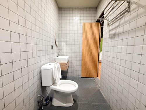 a bathroom with a toilet in a tiled stall at Singgah Sejenak Dieng in Diyeng